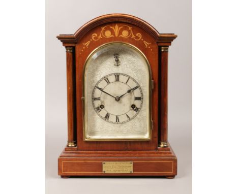 A mahogany cased 8 day bracket clock inlaid and with turned column supports, having silvered dial with silent chime mechanism