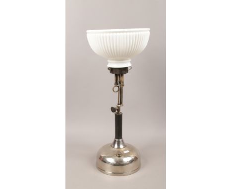 A paraffin lamp with chrome plated base and fluted opaque glass shade.