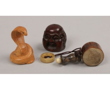 A Chinese horn snuff bottle, Buddha head netsuke and a wooden netuske formed as a snake.