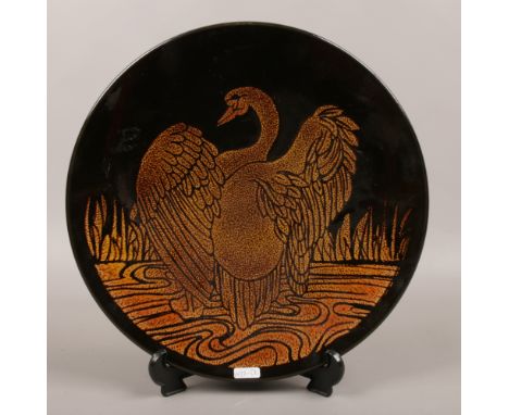 A Poole pottery charger decorated with a stylized swan Aegean pattern.