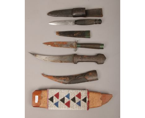A sheathed hunting knife with worked back blade and leather mounted sheath, an Islamic dagger with niello decoration, a Sheff