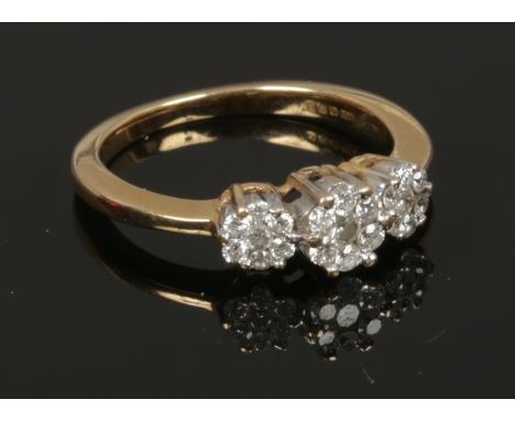 An 18ct gold and diamond triple floriform cluster ring, size K.