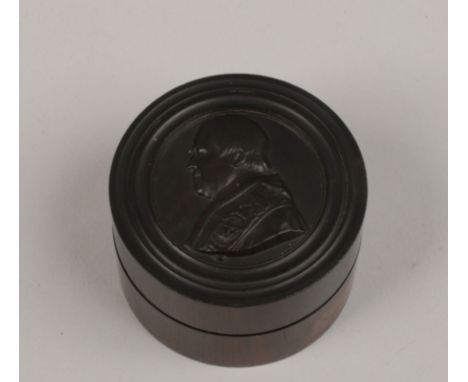 A 19th century hardwood trinket box with threaded cover carved in light relief with a portrait of the Pope.