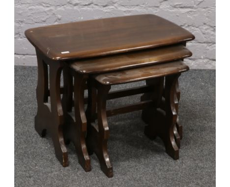 A nest of three Ercol dark oak occasional tables.