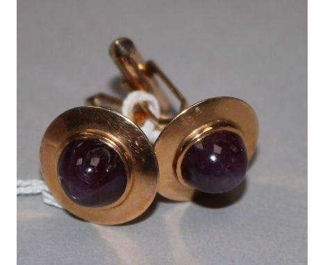 A pair of yellow metal and cabochon star ruby set cufflinks.
