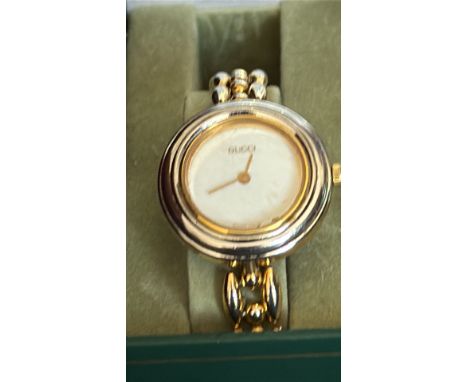 Ladies Gucci Gold-tone watch with white face and four interchangeable coloured bezels rings (red, blue, gold, green), in orig