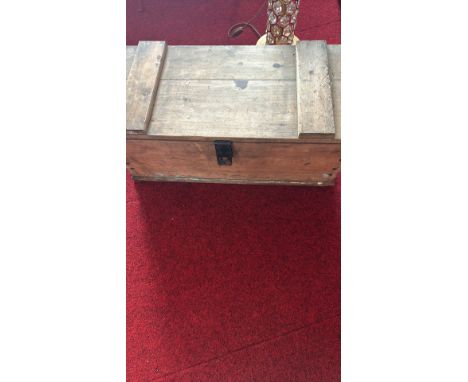 Wooden tool box containing various hand tools including a power drill and pliers.