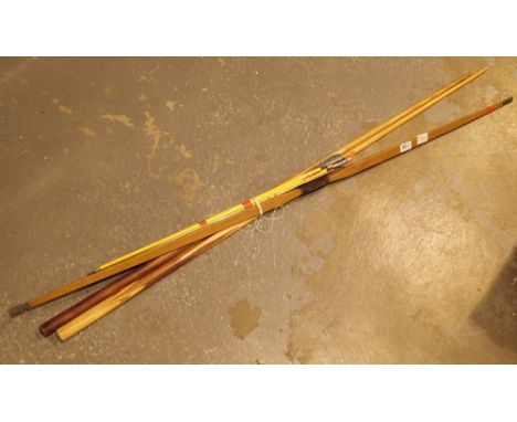 Two vintage pool cues a bow and some arrows 