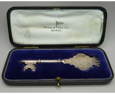 A hallmarked silver key by Walker &amp; Hall, cased, with inscription dated 1923, 63g 