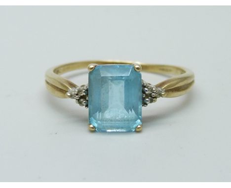 A 9ct gold ring set with six small diamonds and a central topaz, 2.6g, U 
