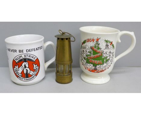 Two commemorative miner's mugs and a miniature miner's lamp 