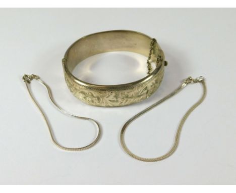 SILVER BANGLE ETC. A broad silver hinged bangle & two silver flat herring bone link bracelets.  Please note that all items in