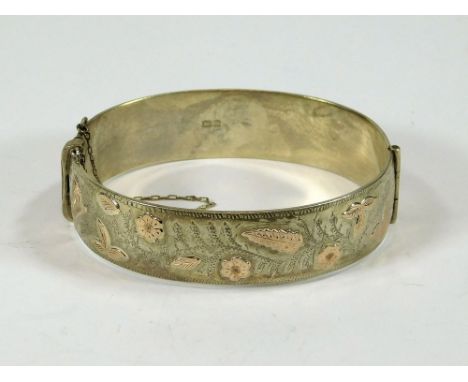 SILVER BANGLE. A late 1960's Victorian-style silver & silver gilt hinged bangle.  Please note that all items in this auction 