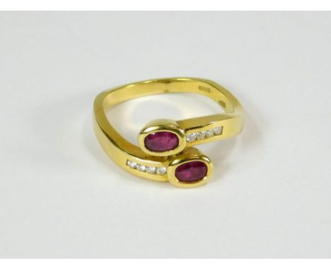 RUBY RING. A Middle Eastern (Dubai) 18ct. gold contemporary ring, set with a pair of rubies & eight channel-set diamonds in a