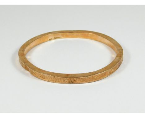 GOLD BANGLE. A 9ct. rose gold, engraved slave bangle (with denting throughout). Approx. 13.5g.  Please note that all items in