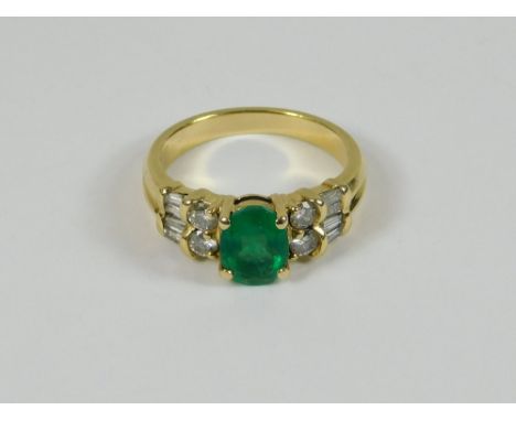 EMERALD & DIAMOND RING. A 14k dress ring set an oval cut emerald, flanked by four brilliant cut diamonds & four baguette cut 