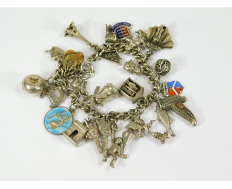 CHARM BRACELET. A silver curb link charm bracelet, hung a variety of silver & enamel charms, some stamped.  Please note that 