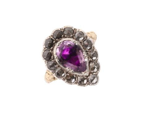 the pear-shaped foil backed amethyst is set within a surround of rose-cut diamonds, in silver and gold, with foliate engraved
