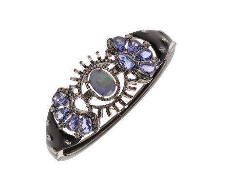 centred with an oval-shaped opal within a surround of baguette-cut and circular-cut diamonds and pear-shaped tanzanites, with