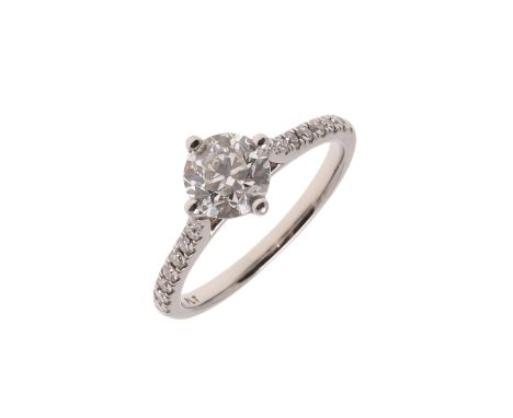 the round brilliant-cut diamond is set with circular-cut diamonds to each shoulder, in platinum, 3.4 grams. Size K  Accompani