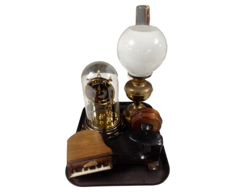 A brass oil lamp with chimney and opaque glass shade together with a 19th century cast iron cobbler's last mounted on a woode