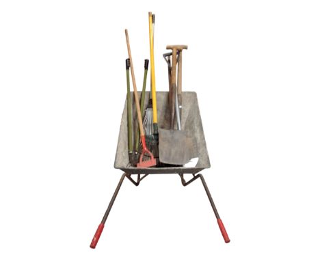 A wheelbarrow containing garden tools.