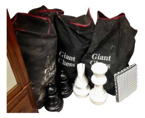 Four bags containing a giant chess board and pieces.
