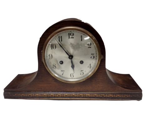 An oak cased eight day mantel clock with silvered dial.