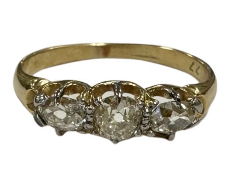 An 18ct gold three stone old-cut diamond ring, the total diamond weight estimated at 0.7 carat, shank also stamped .77, size 