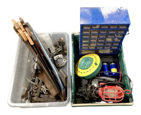Two crates containing handsaws, hand tools, an extension lead, multi drawer chest etc.