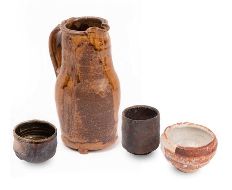 ARR Jim Malone (born 1946) a stoneware jug raised on three small feet, in a dripped brown glaze with linear incisions to the 