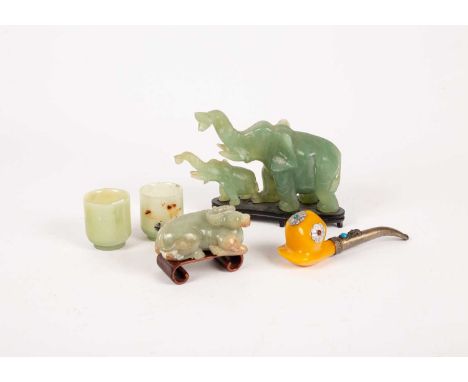 Four Chinese celadon jade carvings, 20th Century, comprising a crouching oxen set on a wooden plinth, 9.5cm long, an elephant