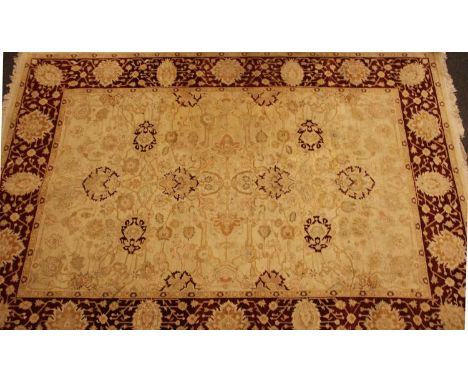 A cream ground Zeigler type carpet, the foliate field within banded burgundy border, 268cm x 185cm