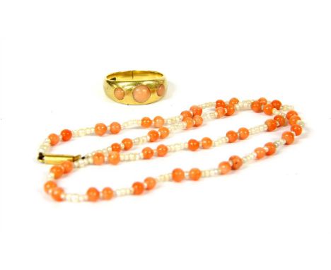 A child's seed pearl and coral bead necklace, the clasp marked 15c and a three stone coral ring marked 18ct, 5.06g, size J½ a