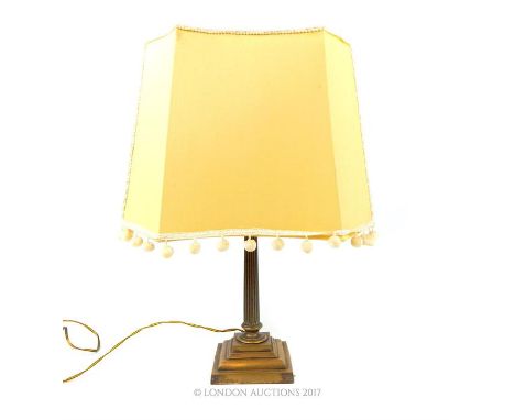 A bronzed brass Corinthian column table lamp, raised on a step down base, with a shade, 50 x 38 x 22cm.