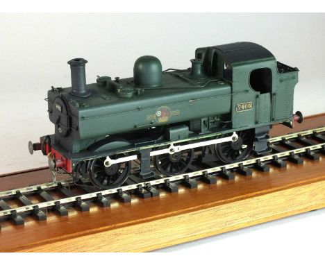 An O-gauge model of a steam locomotive, '7405', 0-6-0, in green livery, with the British Railway logo of a lion rampant in a 