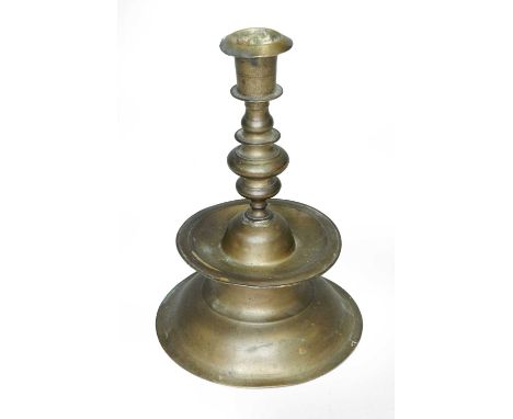 An 18th/19th century, 17th century style, candlestick, with an everted rim above a knoppped stem over a broad circular drip-t