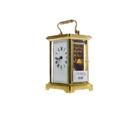 EARLY 20TH CENTURY CARRIAGE CLOCK, with white enamel dial with Roman numerals, the brass five glass case with swing handle, o