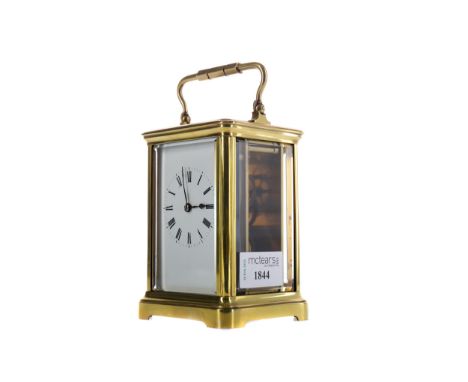 EARLY 20TH CENTURY CARRIAGE CLOCK, with white enamel dial with Roman numerals, the brass five glass case with swing handle, o