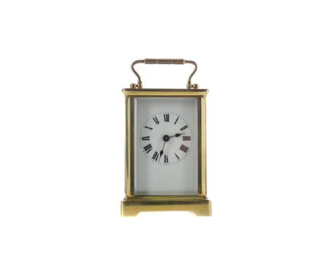 EARLY 20TH CENTURY CARRIAGE CLOCK, with white enamel Roman numeral dial, the brass five glass case with swing handle, on brac