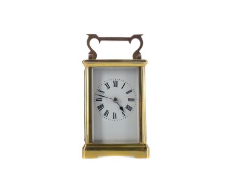 EARLY 20TH CENTURY CARRIAGE CLOCK, with white enamel dial with Roman numerals, the brass four glass case with swing handle, o