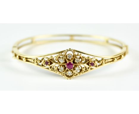 A 9ct Gold Diamond and Ruby Stiff Bangle, Modern, set with a small centre ruby stone surrounded by five small white diamonds 
