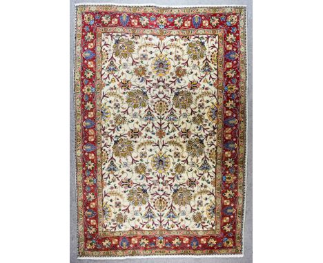 A 19th Century Tabriz Carpet, woven in colours of ivory, fawn and wine, the field filled with trailing leaf and floral orname
