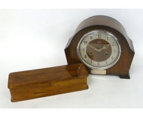 AN OAK MANTEL CLOCK WITH STRIKING MOVEMENT AND A POLISHED WOOD GLOVE BOX 