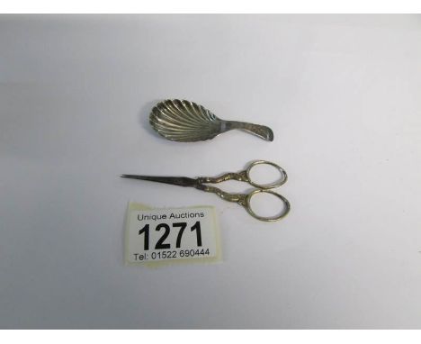 A Georgian silver caddy spoon and a pair of antique white metal scissors