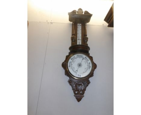 A carved oak barometer