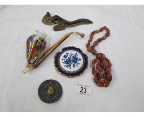 A squirrel nut cracker, a glass pipe, a Stratton powder compact, a necklace and a brooch