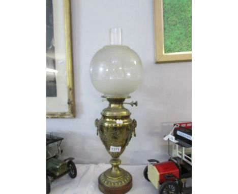 A brass urn shaped oil lamp with etched shade