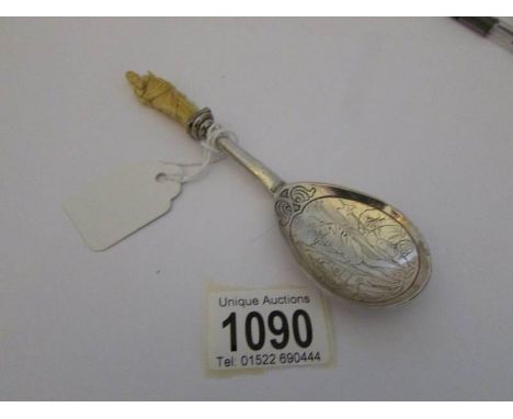 An early 20th century silver anointing spoon with ivory figure of St Paul finial