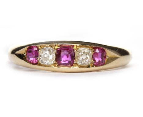 EARLY TWENTIETH CENTURY RUBY AND DIAMOND FIVE STONE RINGthe boat shaped bezel with a central cushion shaped ruby and two furt